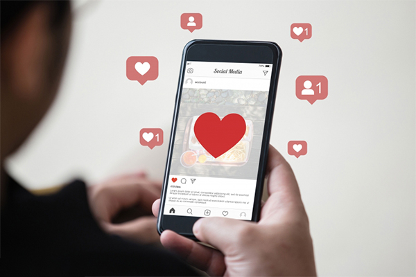 Ein Handy worauf Instagramm geöffnet ist. Mehrere Like Zeichen und Herzen sind zu sehen.